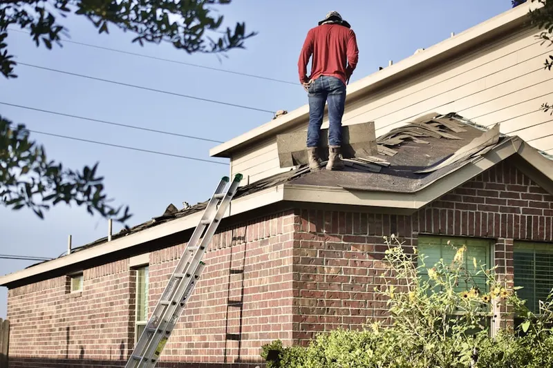 Professional roofer working on a residential roof in Bressler
